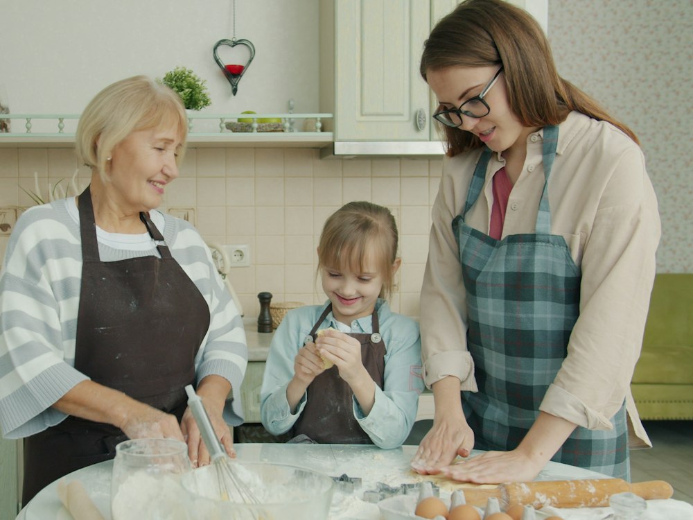 Nonna, mamma e bambina che preparano un impasto insieme in cucina