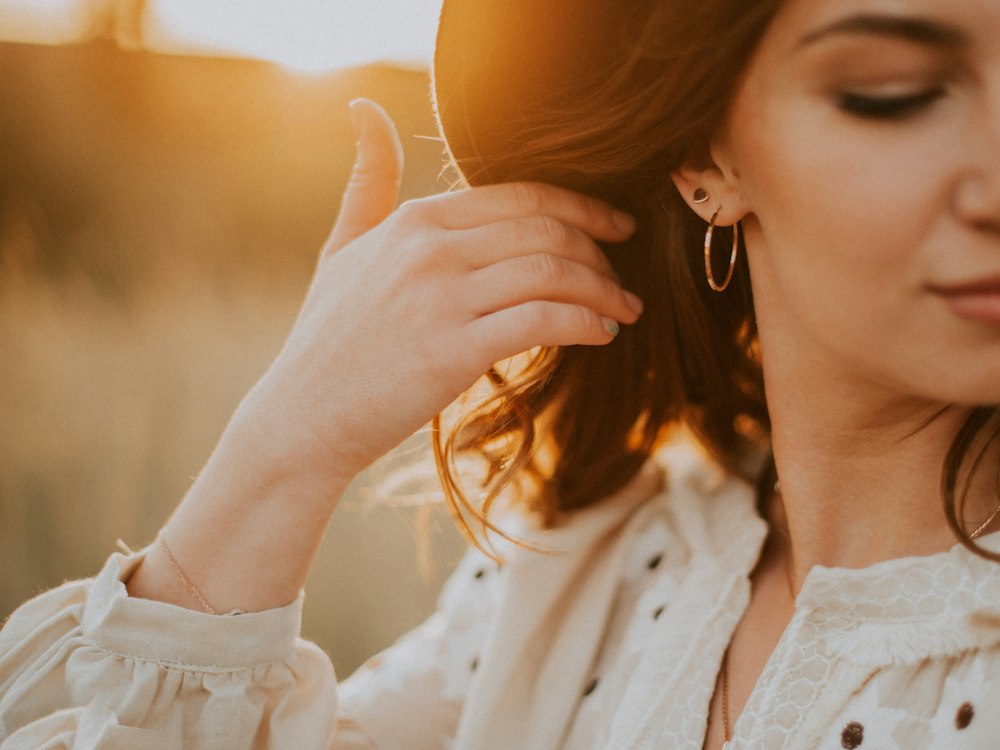 Ragazza che si tocca l'orecchino, alla luce del tramonto