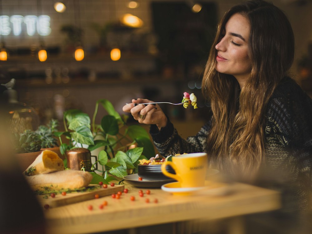 Ragazza che assapora un piatto di verdure al tavolo